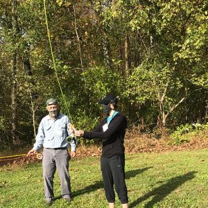 Instructor showing a student how to cast a fly rod