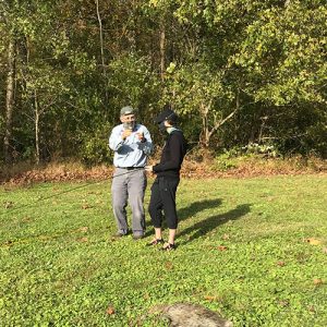 Instructor explaining casting a fly rod to a student