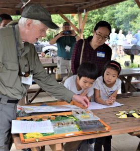 Instructor shows Ping and her children different types of flies